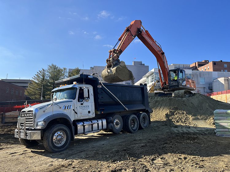 Dump truck getting loaded up with dirt from the job site