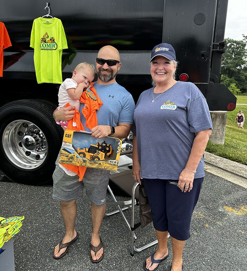 posing outside of Comer Construction booth at touch a truck